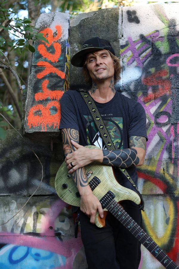 Man hold the guitar on hand With wearing cap