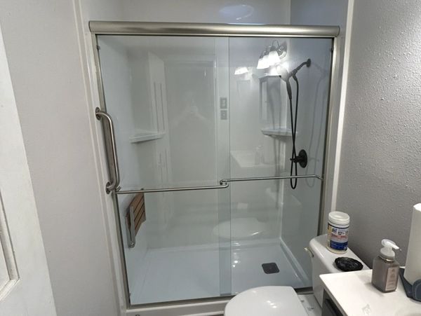 A bathroom with a toilet, sink and shower.