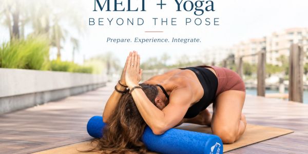 Woman practicing MELT and yoga with foam roller outdoors.