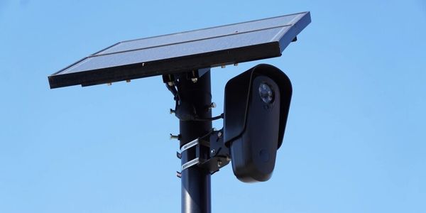 Solar-powered security camera on a pole.