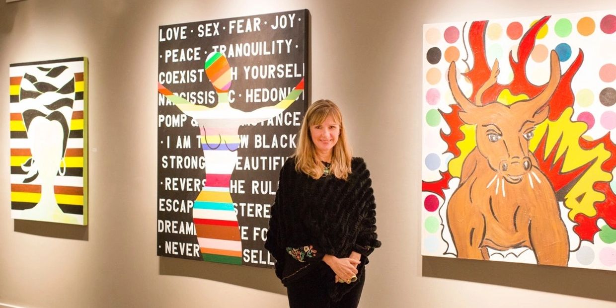 Woman standing in an art gallery with colorful paintings.