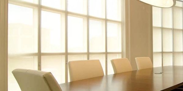 Large, bright, modern boardroom that features illusion window shades. 