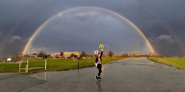 Meg from Stand with Meg standing under a double rainbow knowing God's promises