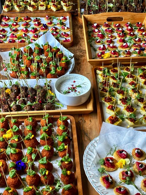 A spread of delicious canapes: smoked salmon blinis, tortillas, koftas and arancini balls