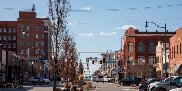 Sunny day on a quiet city street with historic brick buildings.