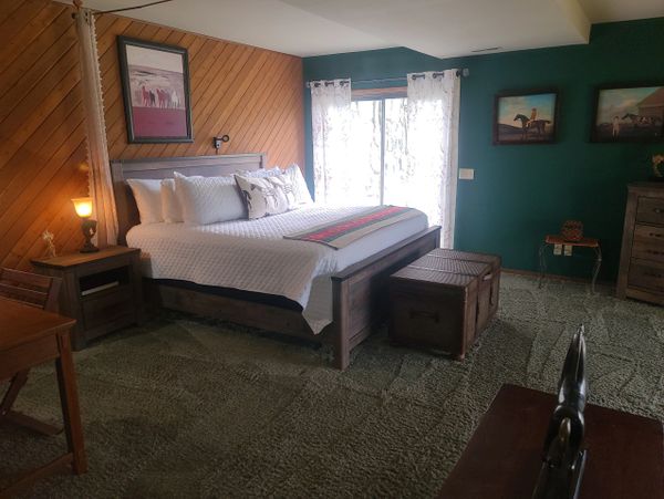 Cozy rustic bedroom with wooden furniture and green walls.
