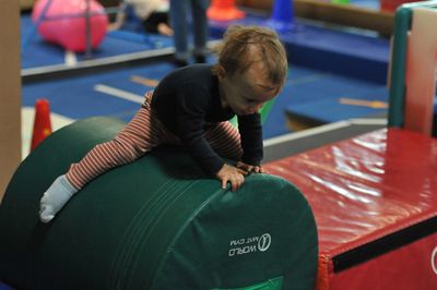 Un bébé joue sur un équipement de gym pour enfants.