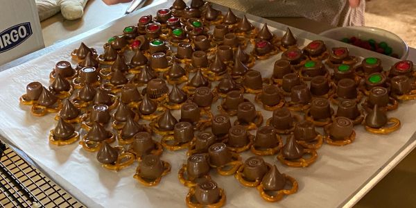 Tray of pretzel, chocolate, and candy treats on wax paper.