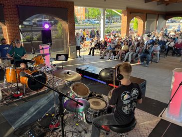 Young musicians performing live for an outdoor audience.