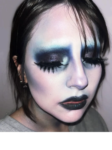 Close-up of a person with dramatic dark and blue artistic makeup.