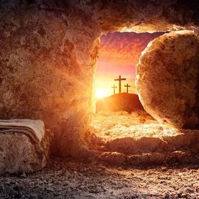 Empty tomb with sunlight and three crosses on a hill in the distance.
