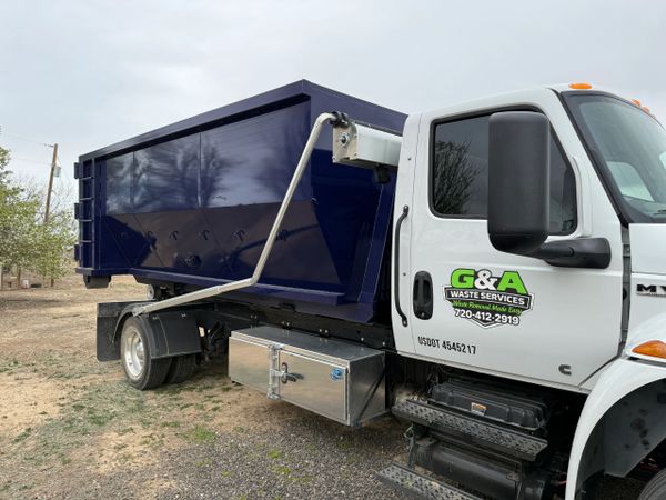 G&amp;A Waste Services truck with a large blue dumpster container on the back.