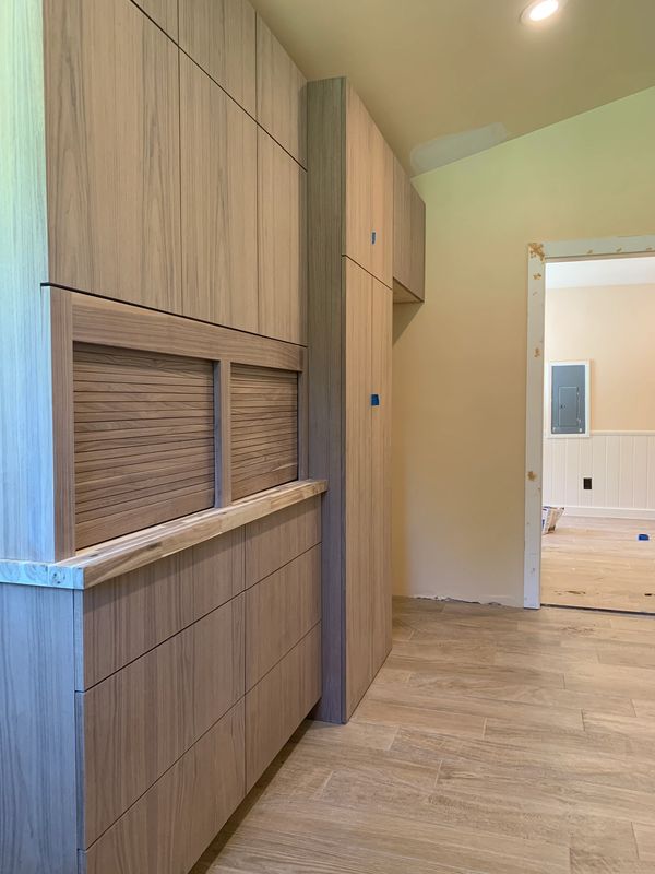 Custom walnut kitchen cabinets with butcher block countertop. Cabinetry has tambour doors