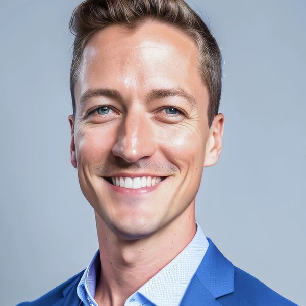 A photo of Shane Regier, a life, leadership and executive coach, wearing a blue sit and white shirt.