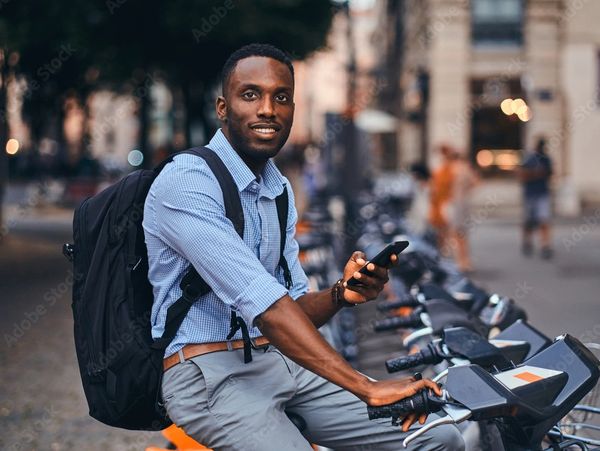 A man sitting on a bike with a phone in his hands