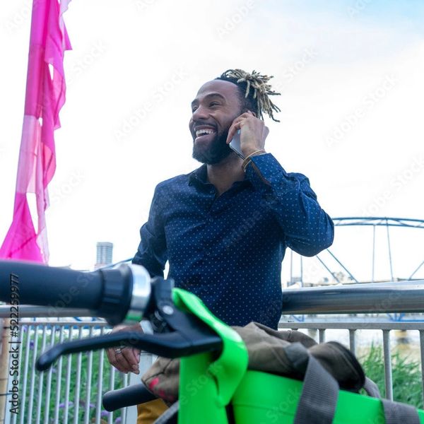 A man talking on the phone with a bike near him