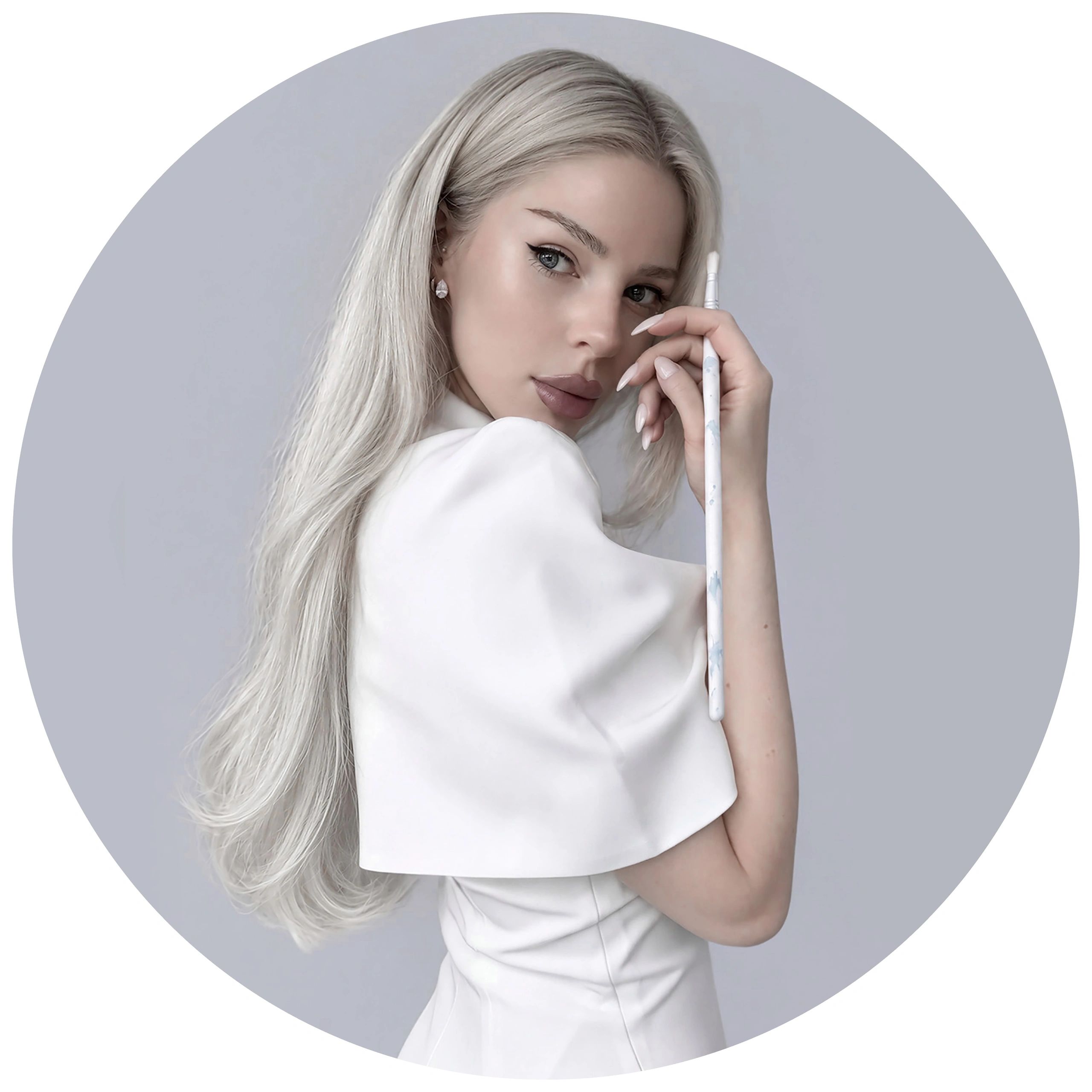 Woman with long platinum blonde hair holding a brush.