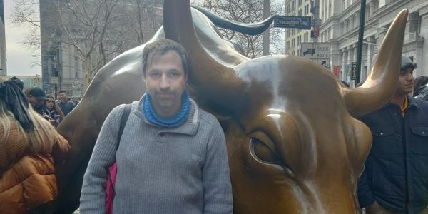 Image of Dr. Benjamin Gibson by the bull sculpture in New York City.