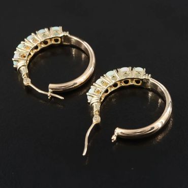 Elegant gold hoop earrings with white gemstone accents.