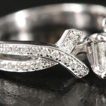 Close-up of a silver ring encrusted with small diamonds on a dark surface.