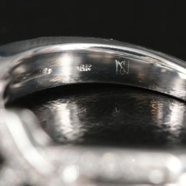 Close-up of a ring's inner band with 18K and maker's mark stamps.