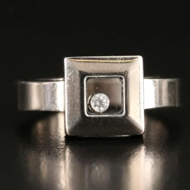 Silver ring with a square top and small diamond.