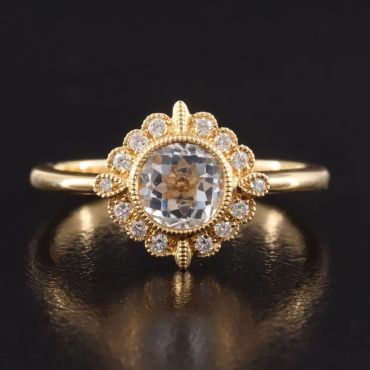 Gold ring with a central diamond and surrounding smaller diamonds.