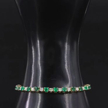 Elegant green and white gemstone bracelet on black display.