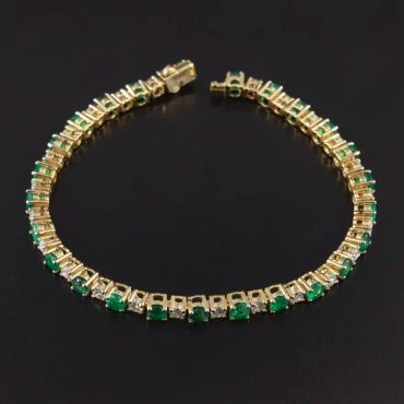 Gold bracelet with green and white stones.