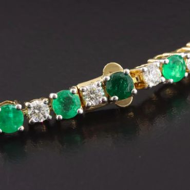 Gold bracelet with emerald and diamond stones.