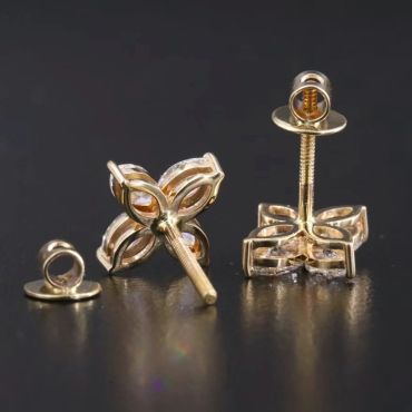 Gold flower-shaped stud earrings with clear stones.