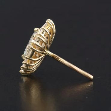 Gold and diamond stud earring on a black surface.