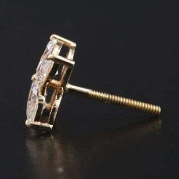 Close-up of a gold earring with diamonds on a black background.