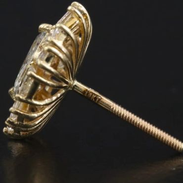Close-up of a gold stud earring with a gemstone.