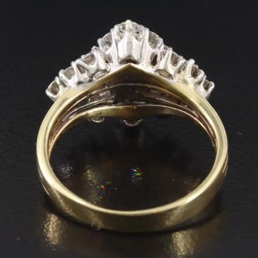 Gold ring with diamonds on a black surface.