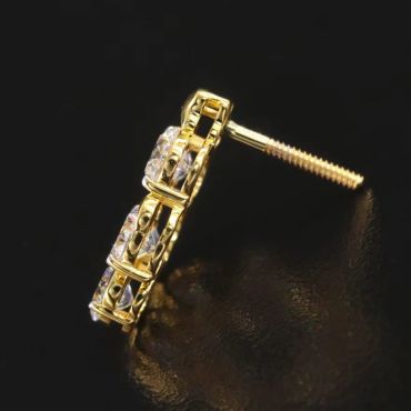 Gold and diamond stud earring on black background.