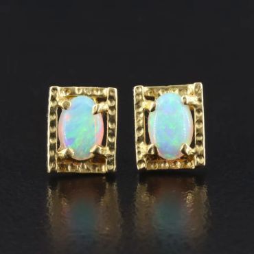 Gold earrings with oval opal stones.