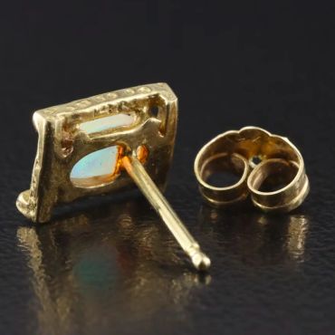 Close-up of a gold earring stud and its backing.