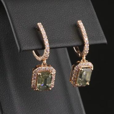 Elegant gold earrings with green gemstones and diamonds.