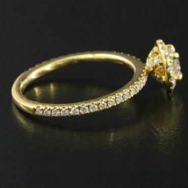 Gold ring with diamonds on black surface.