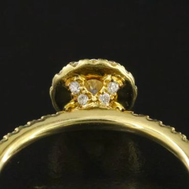 Close-up of a gold ring with diamond accents under the setting.
