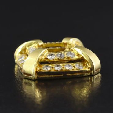 Gold and diamond-studded jewelry piece on black surface.