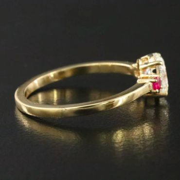Elegant gold ring with a red gemstone and small diamonds.