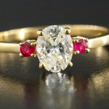 Gold ring with a large diamond and two rubies.