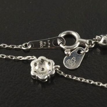 Close-up of a silver necklace clasp with purity marks.