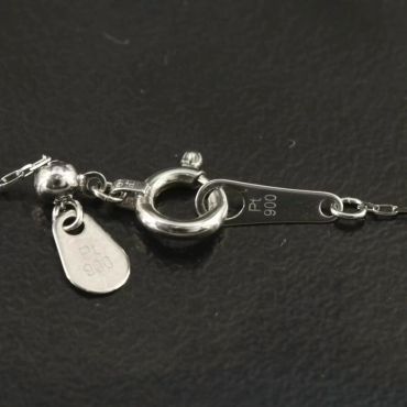 Close-up of a silver necklace clasp marked PT 900.