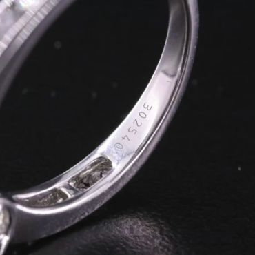 Close-up of a 14K white gold ring & inner band with engraved numbers 302540