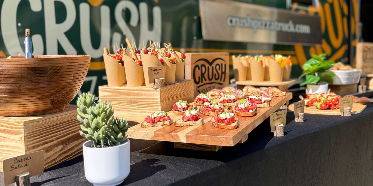 Gourmet appetizers and salads beautifully displayed at an outdoor food stall.