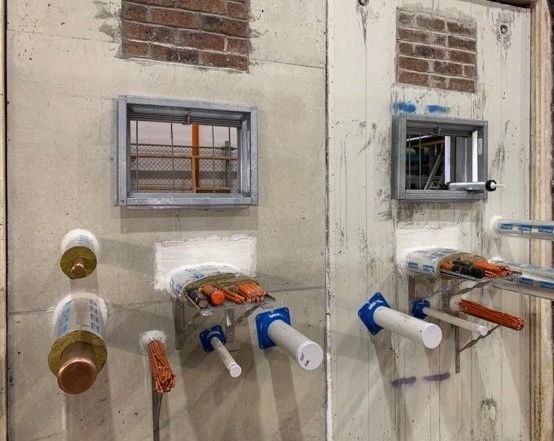A mockup firewall with various service penetration fire seals A mockup firewall with various service penetration fire seals
