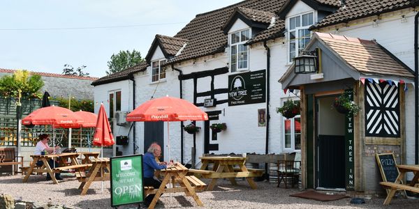  People enjoying the sunshine in the front Beer Garden At The Yew Tree Inn, Colwall